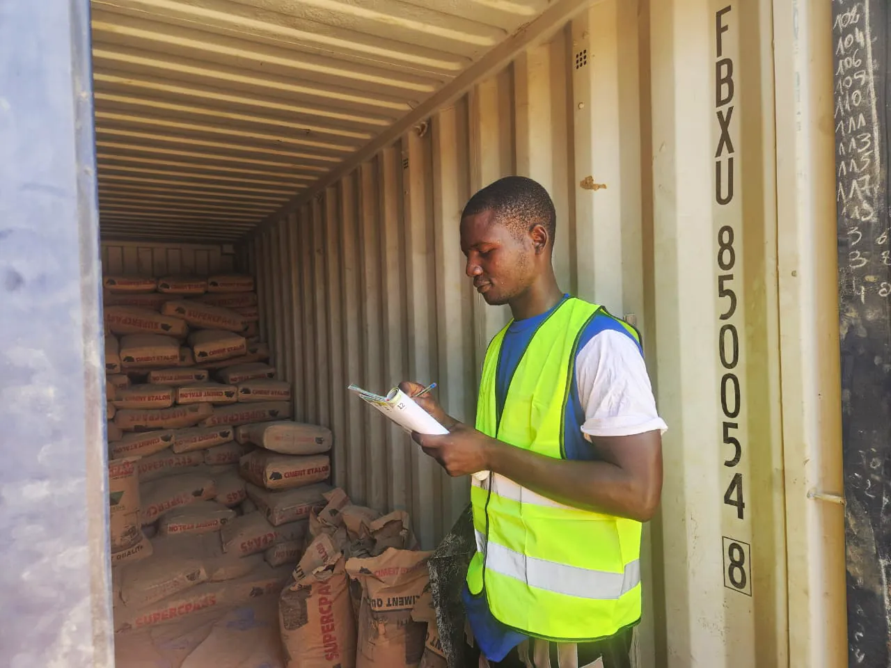 Steve Ouedraogo responsable logistique et surveillance de chantier en train de faire l'inventaire du ciment dans le centenaire sécurisé